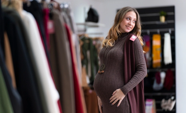 Беременная женщина меряет одежду