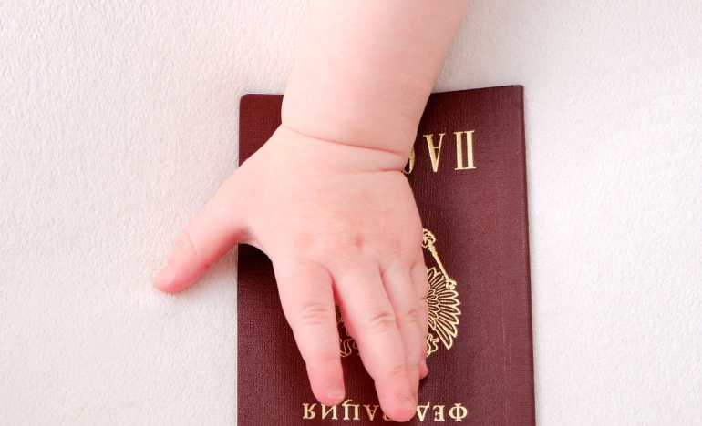 Детская ручка держит паспорт гражданина РФ