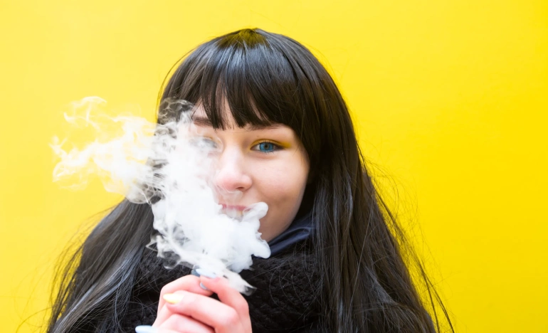 Девочка подросток курит электронную сигарету